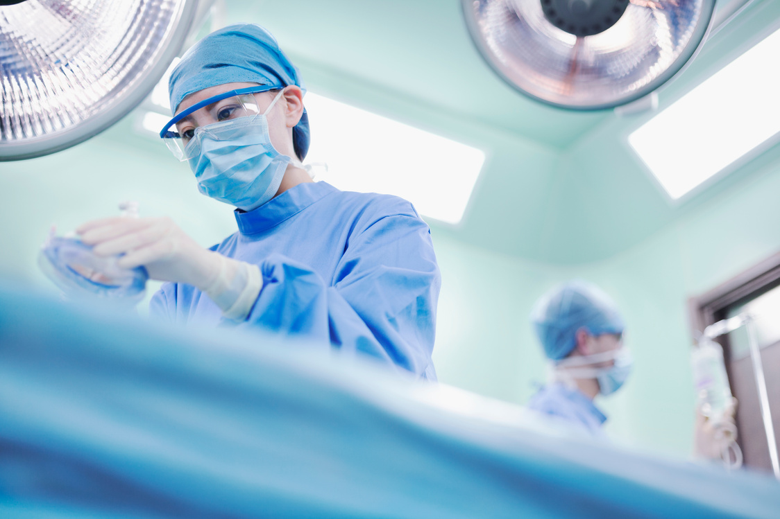 Nurse holding anesthesia mask in operating room