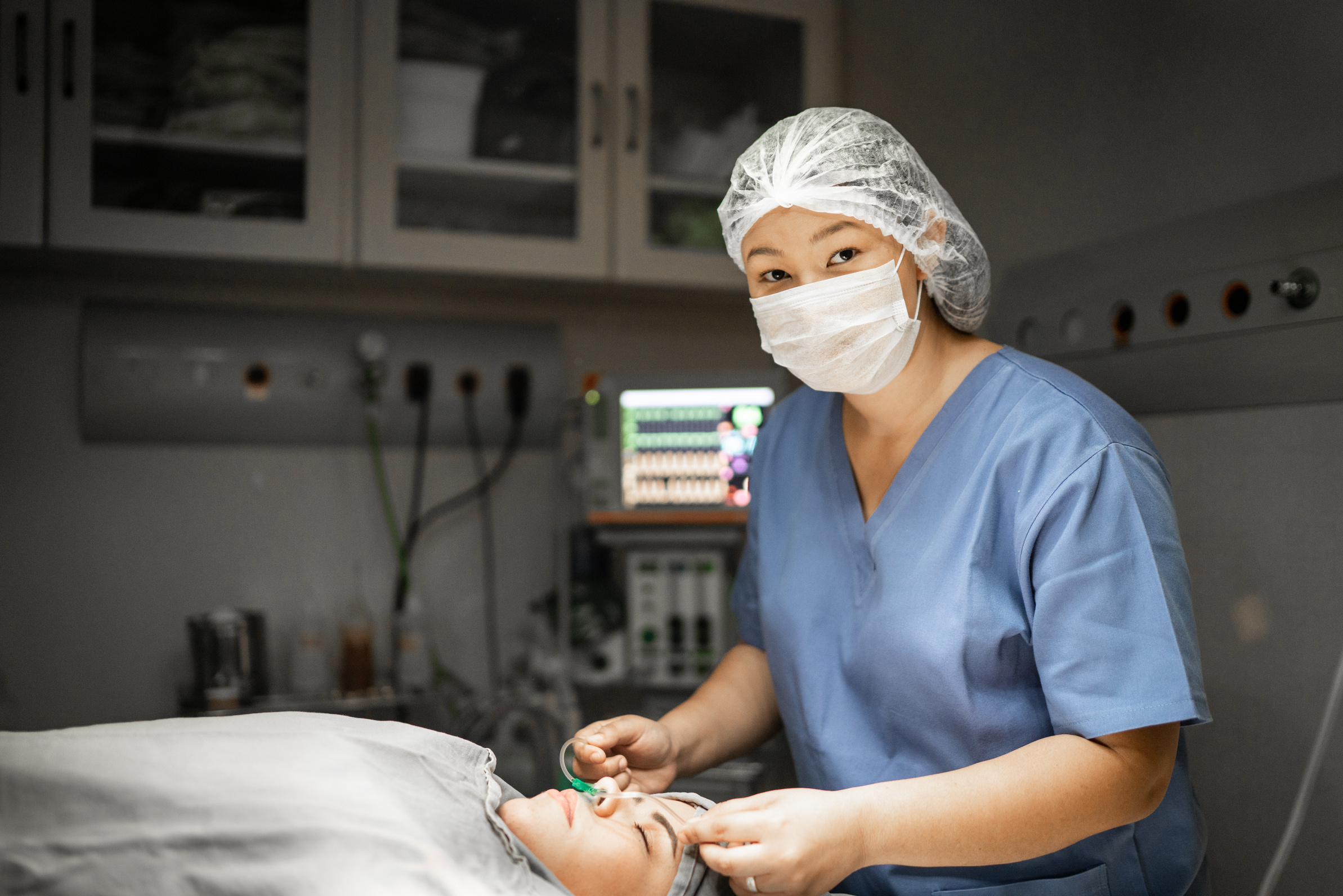 Portrait of anesthetist / nurse preparing patient to surgery at operating room in hospital